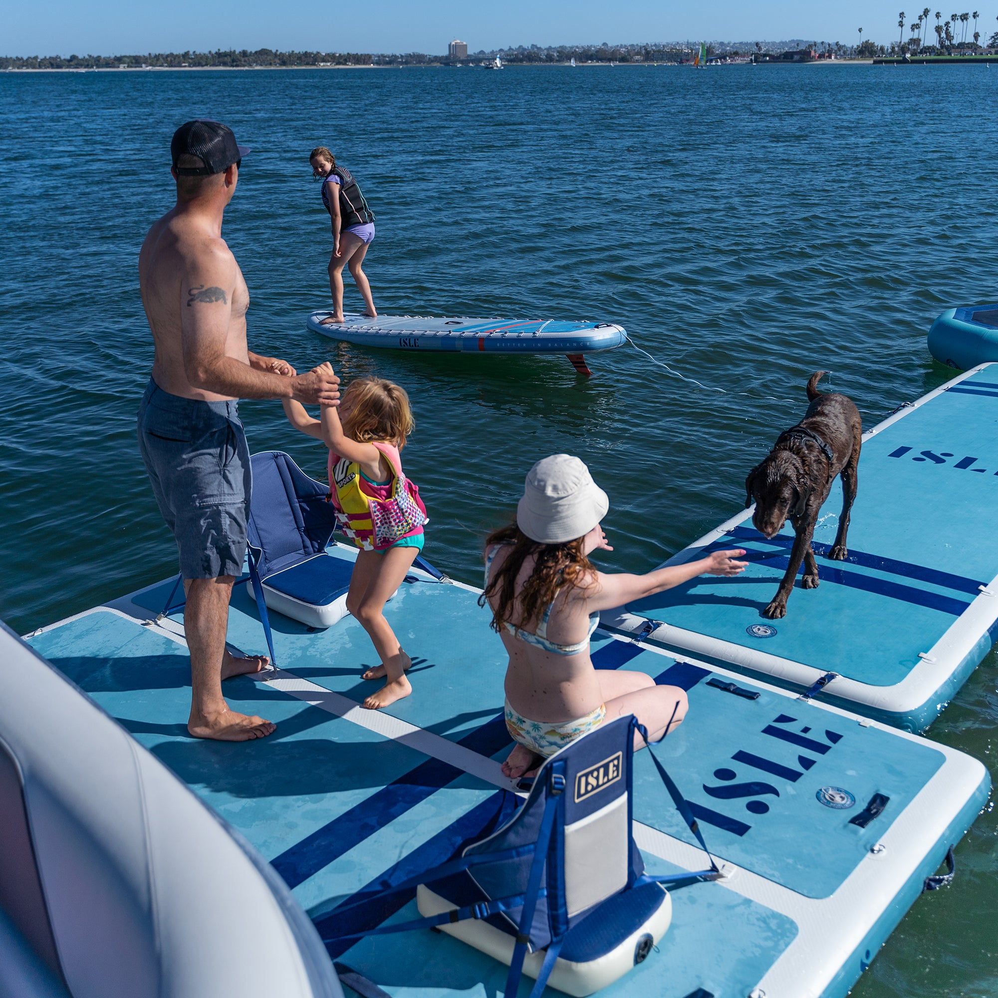 Family Using Base Camp Blue Inflatable Dock in A Bay