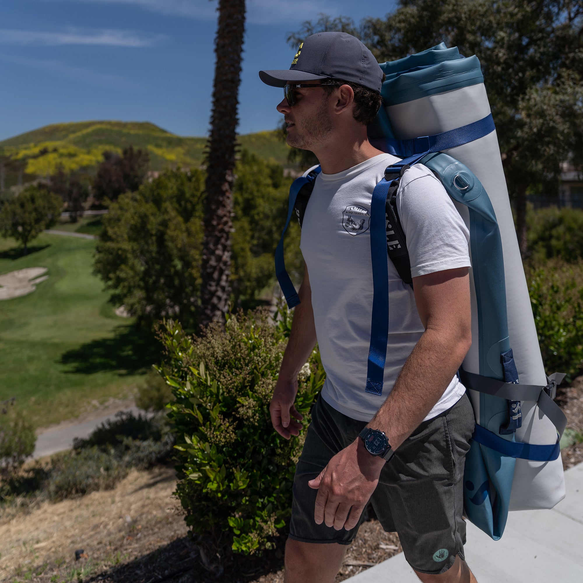 Man Wearing The Base Camp Blue Inflatable Dock With The Minimalistic Carry System
