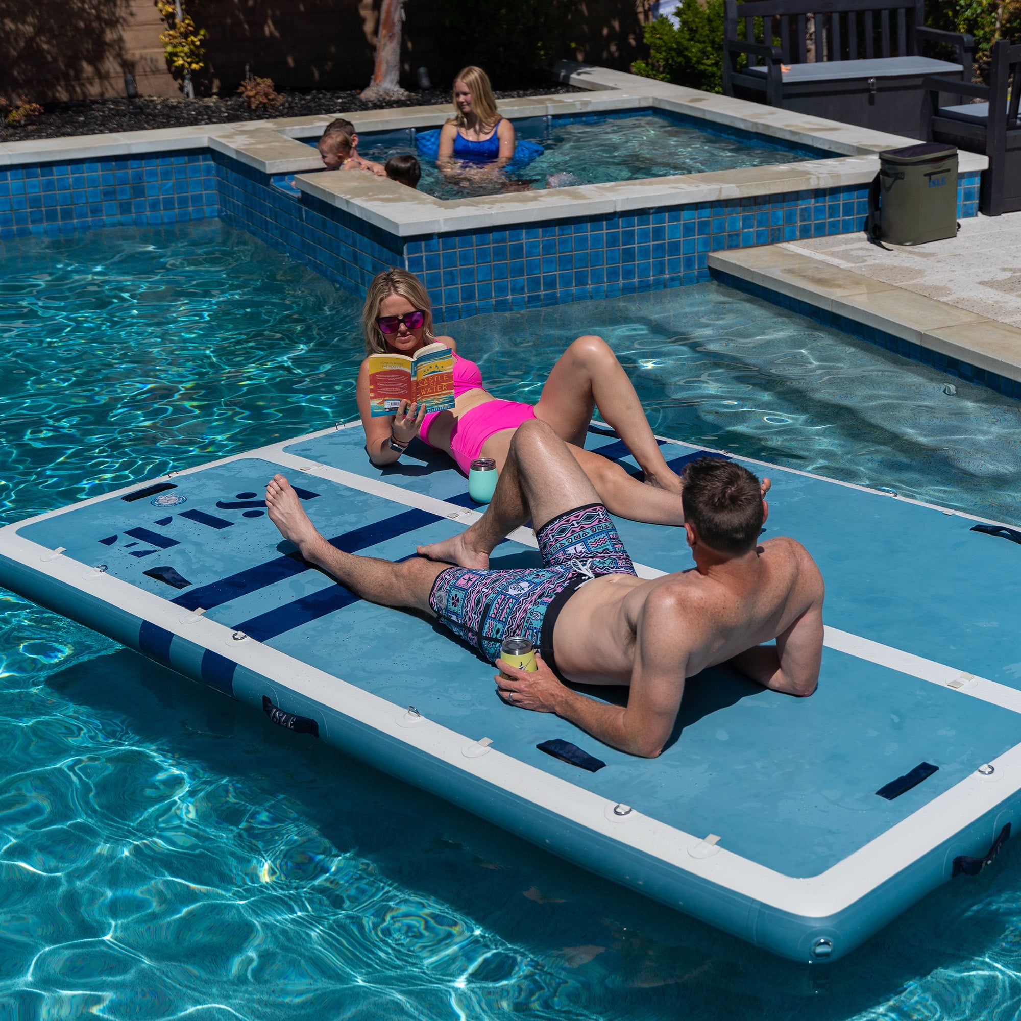 Couple Using Base Camp Blue Inflatable Dock In A Pool