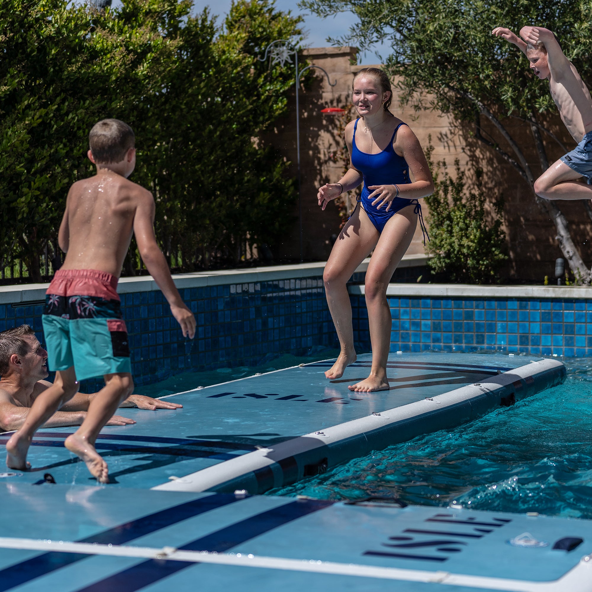 Kids Playing On The Base Camp Blue Inflatable Dock in a Pool