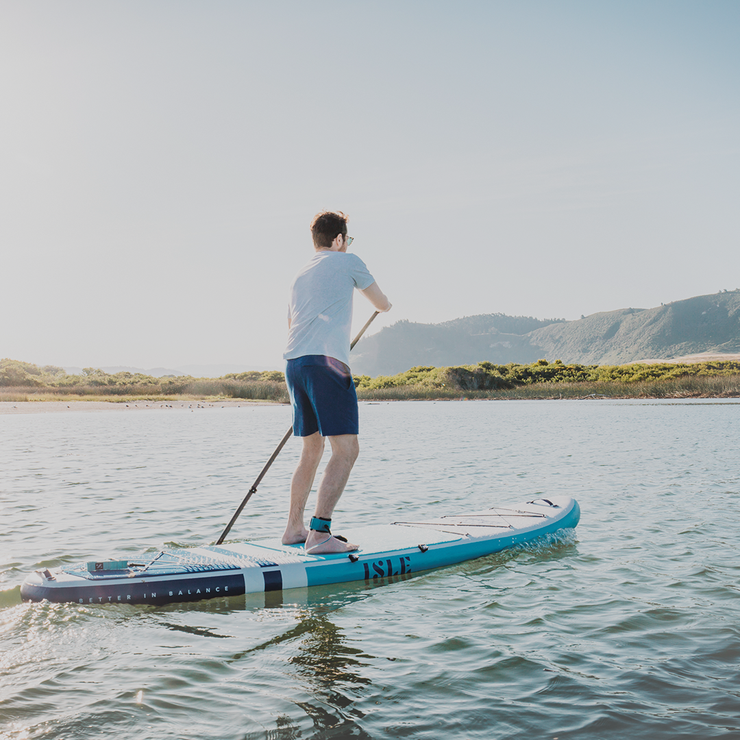 man paddling away, on blue paddle board