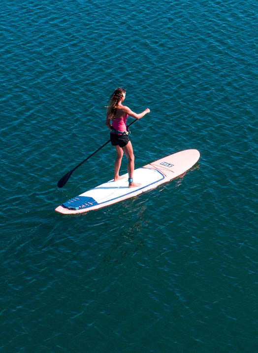 Women Paddle Boarding On The Coral Versa Paddle Board